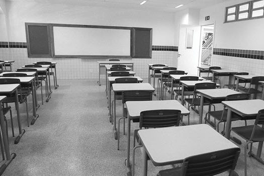In an empty classroom, desks are arranged in rows.