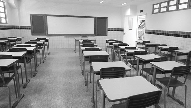In an empty classroom, desks are arranged in rows.
